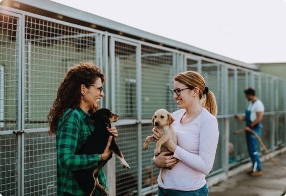 a couple of women holding a dog