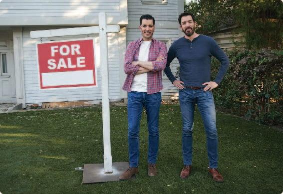 two men standing in front of a sign