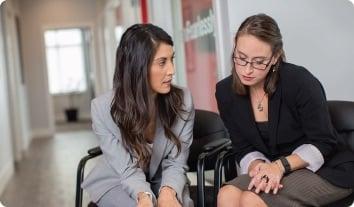 a person sitting next to another woman