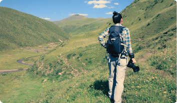 a man with a camera on a mountain