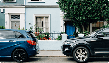 a couple of cars parked on the side of a street