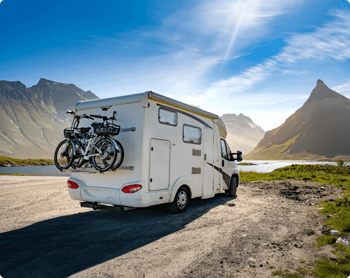 a white rv with bicycles on the roof