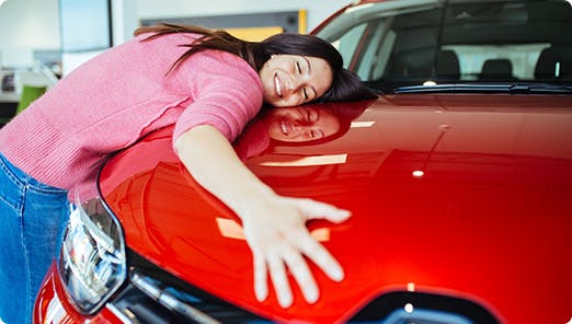 a person leaning on a red car