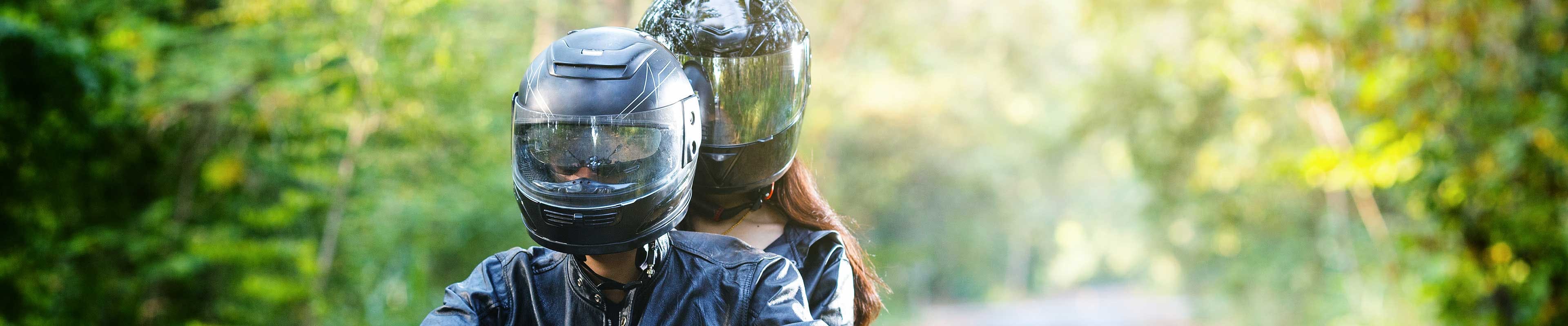 Couple riding motorcycle while wearing helmets