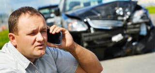 A man on a phone call after a car crash